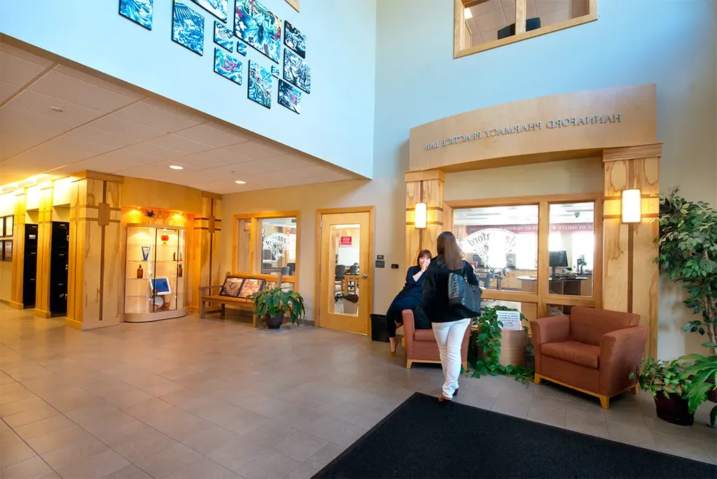 A woman walks through the interior entrance to the School of Pharmacy building