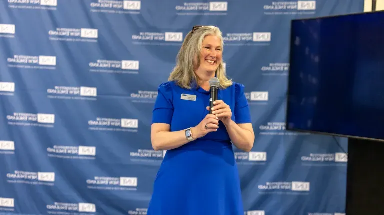 UNE's Alethea Cariddi speaks into a microphone