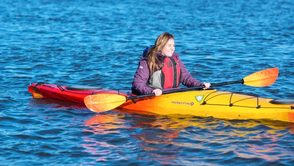 A student kayaks in a river