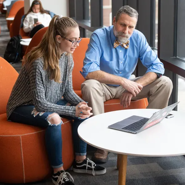 A faculty member assists a student