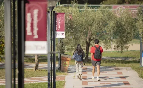 Students walk along a path at the American College of Thessaloniki in Greece