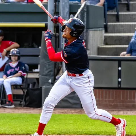 A baseball player follows through with a swing at Hadlock Field in Portland